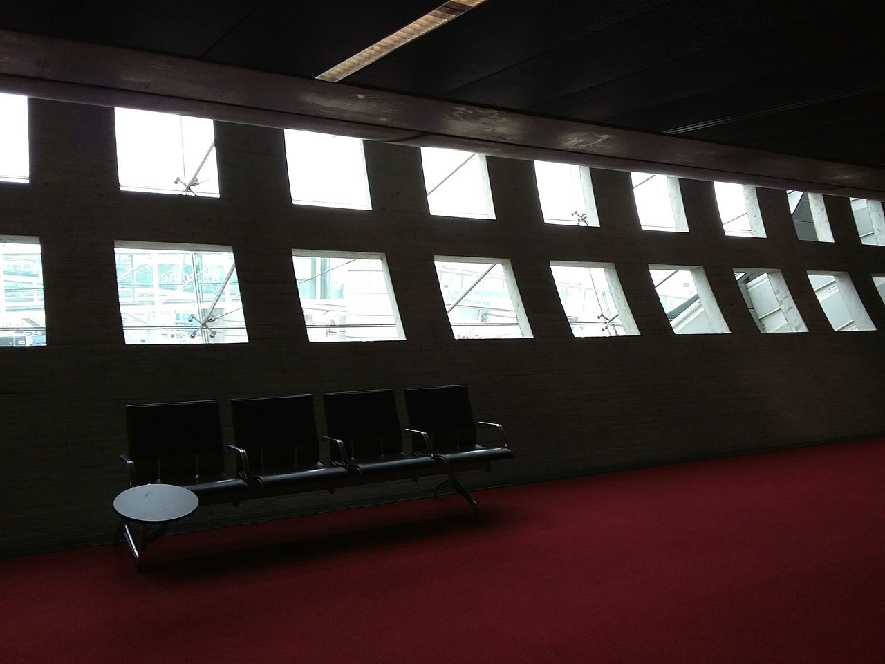 At Paris Charles de Gaulle airport. · France cdg Hallway Waiting Area Bench rest windows light and shadow Framed interior design modern cold